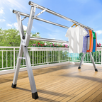 Outdoor drying rack with clothes on a wooden deck against a blue sky.