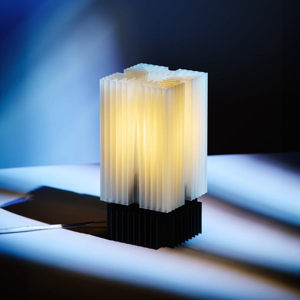 Modern table lamp with geometric design on a reflective surface