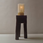 Tall, ribbed lamp with a textured base and cylindrical shade on a neutral background