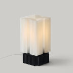Modern table lamp with white and black design on a gray background
