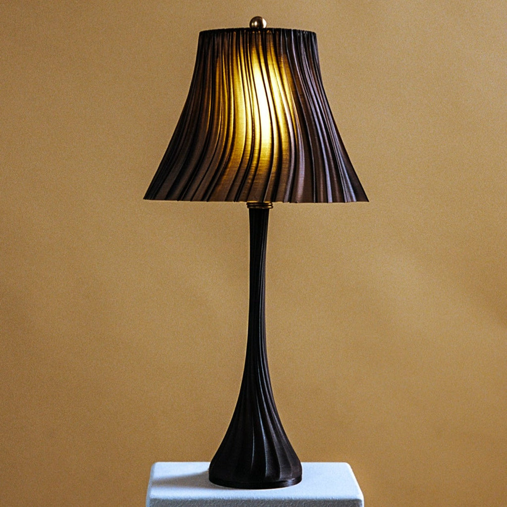 Black table lamp with pleated shade on a beige background