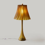 Gold table lamp with ribbed shade on a light gray background