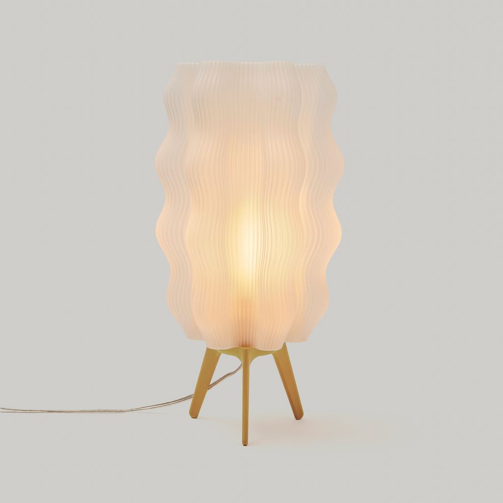 Table lamp with wavy lampshade on a light gray background