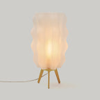 Table lamp with wavy lampshade on a light gray background