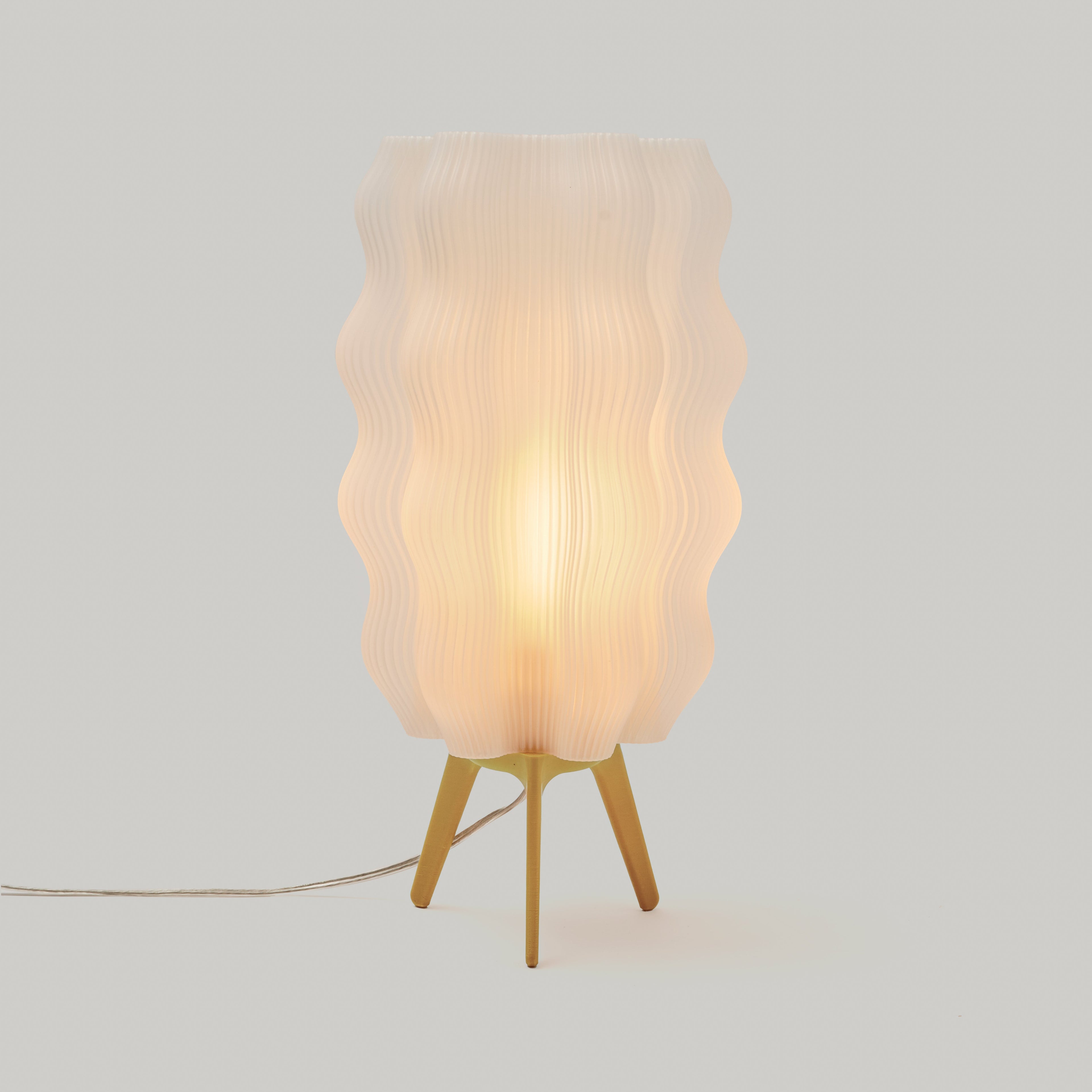 Table lamp with wavy lampshade on a light gray background