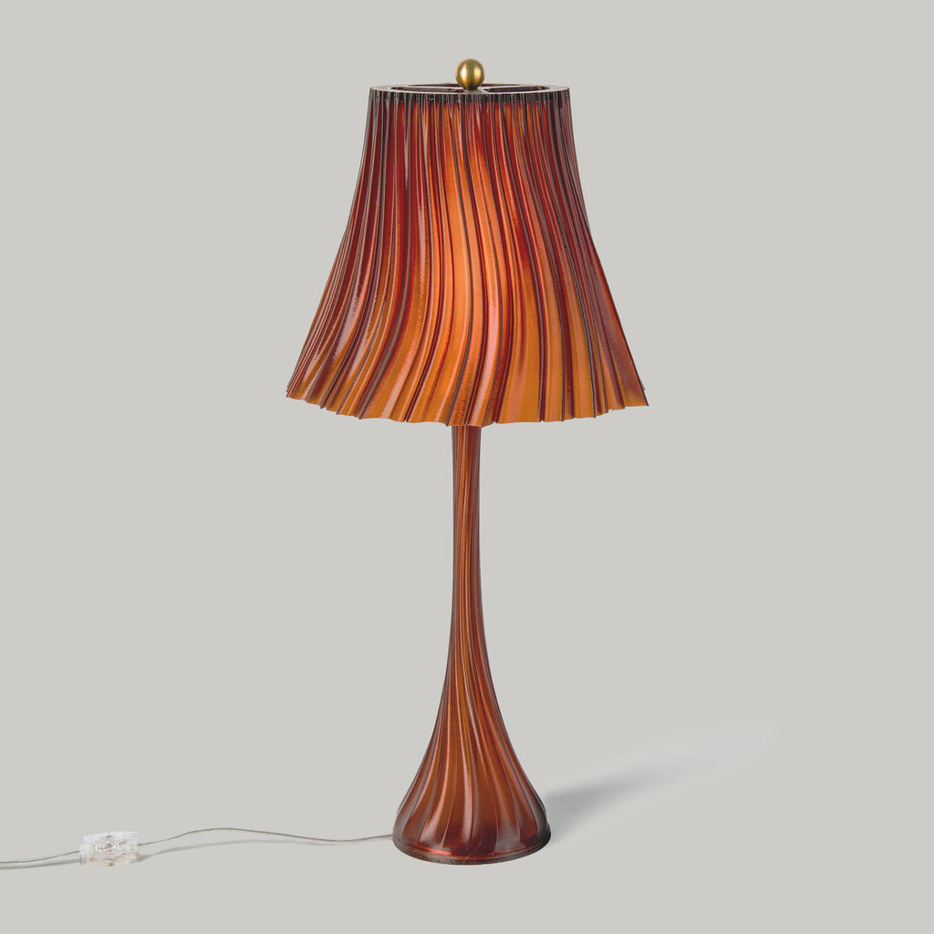 Table lamp with a brown and orange striped shade on a gray background