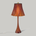 Table lamp with a brown and orange striped shade on a gray background