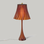 Table lamp with a brown and orange striped shade on a gray background