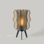 Table lamp with wavy glass shade on a gray background