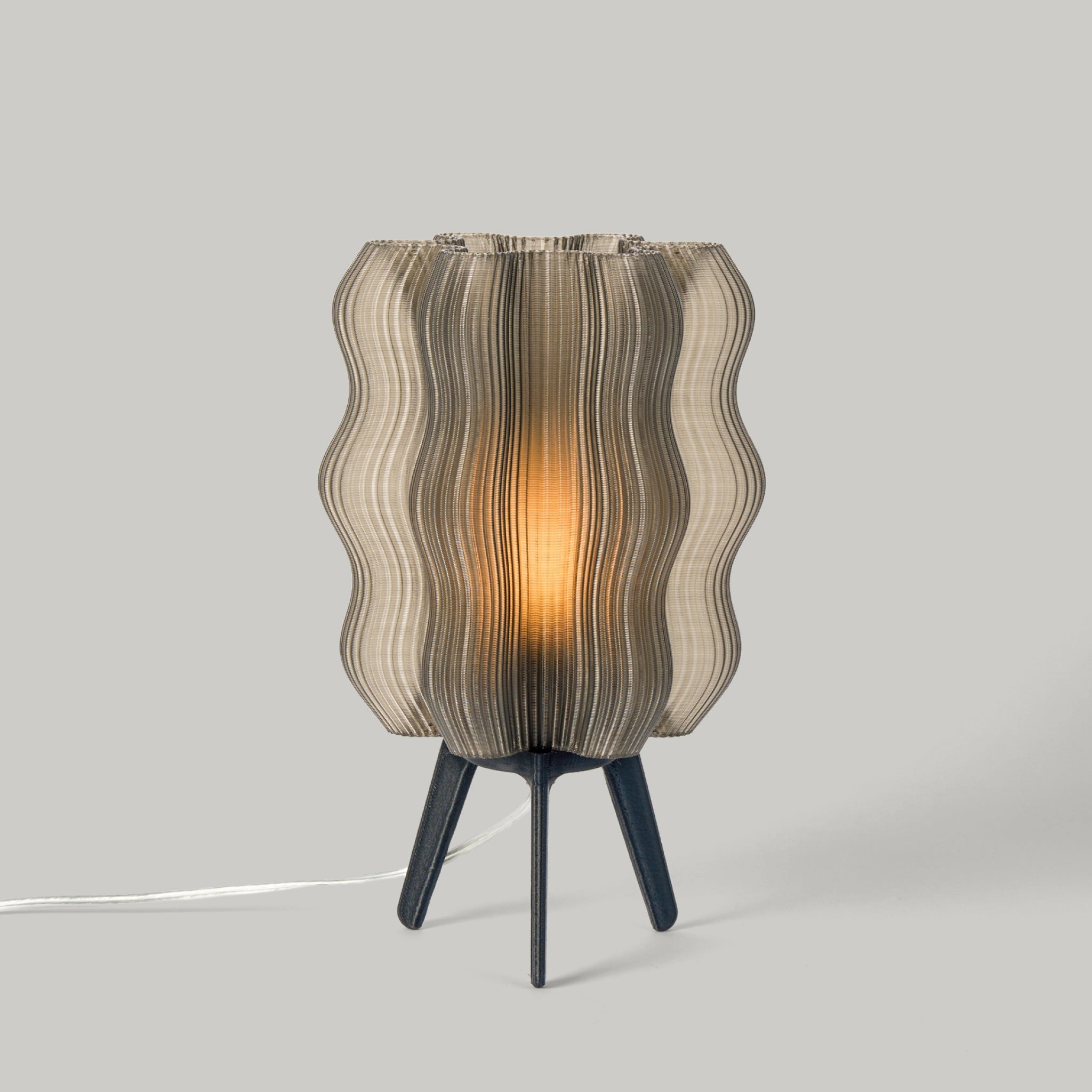 Table lamp with wavy glass shade on a gray background
