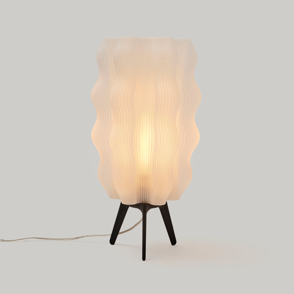 Table lamp with wavy plastic shade on a plain background